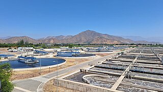 Grosse Kläranlage mit mehreren runden und rechteckigen Becken zur Wasseraufbereitung.