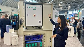 Mitarbeiterin von Martin Systems zeigt Demonstrator mit Filtertechnik